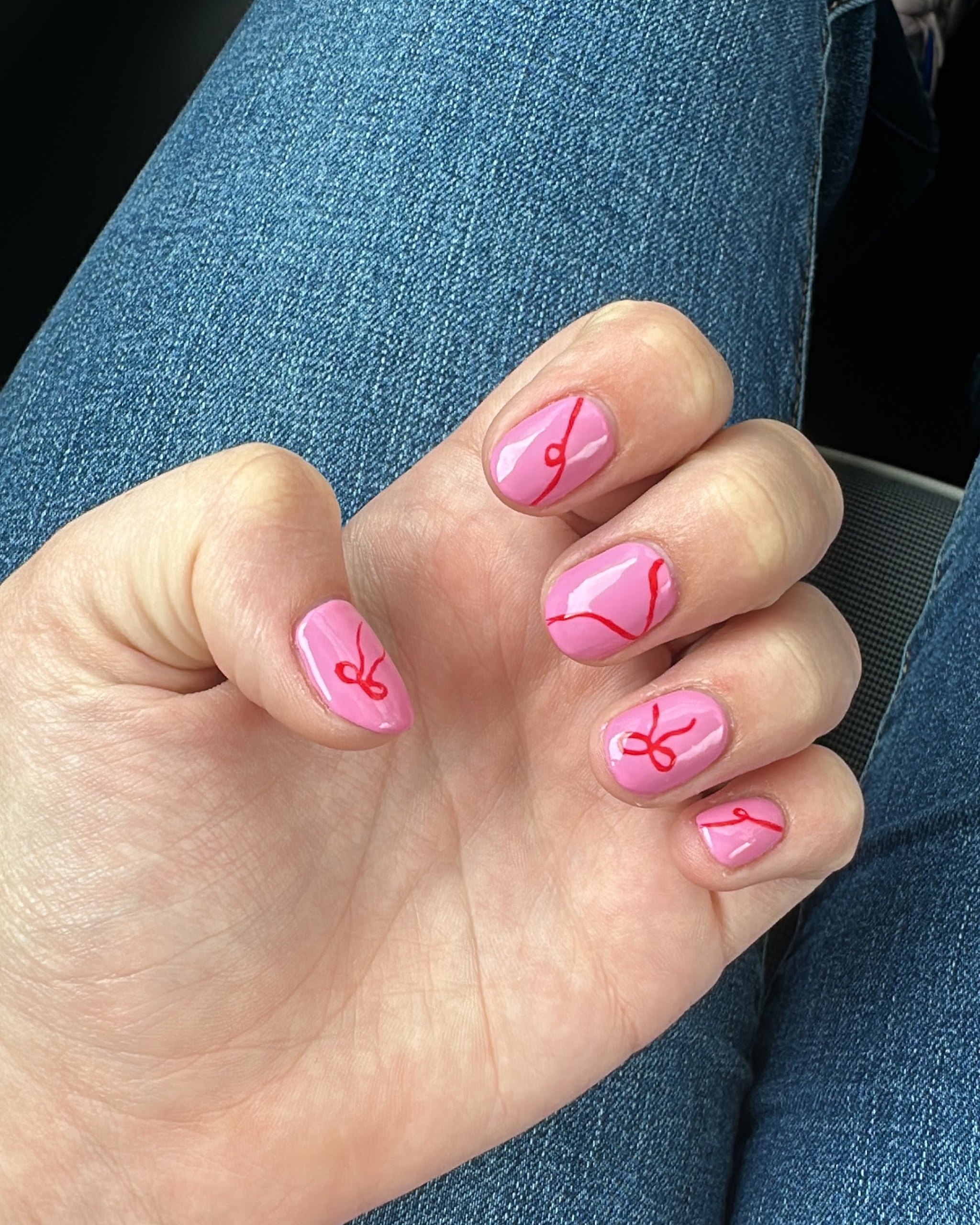 Hand met roze nagels met een rood strikje in lijntekening
